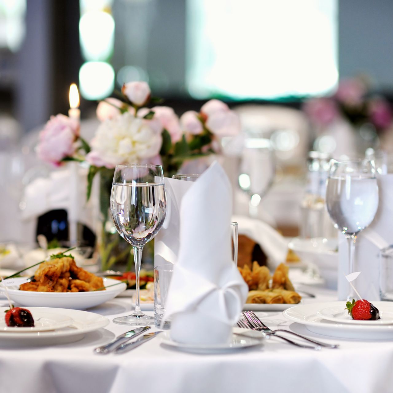A dinner table set with glasses and napkins for registered guests